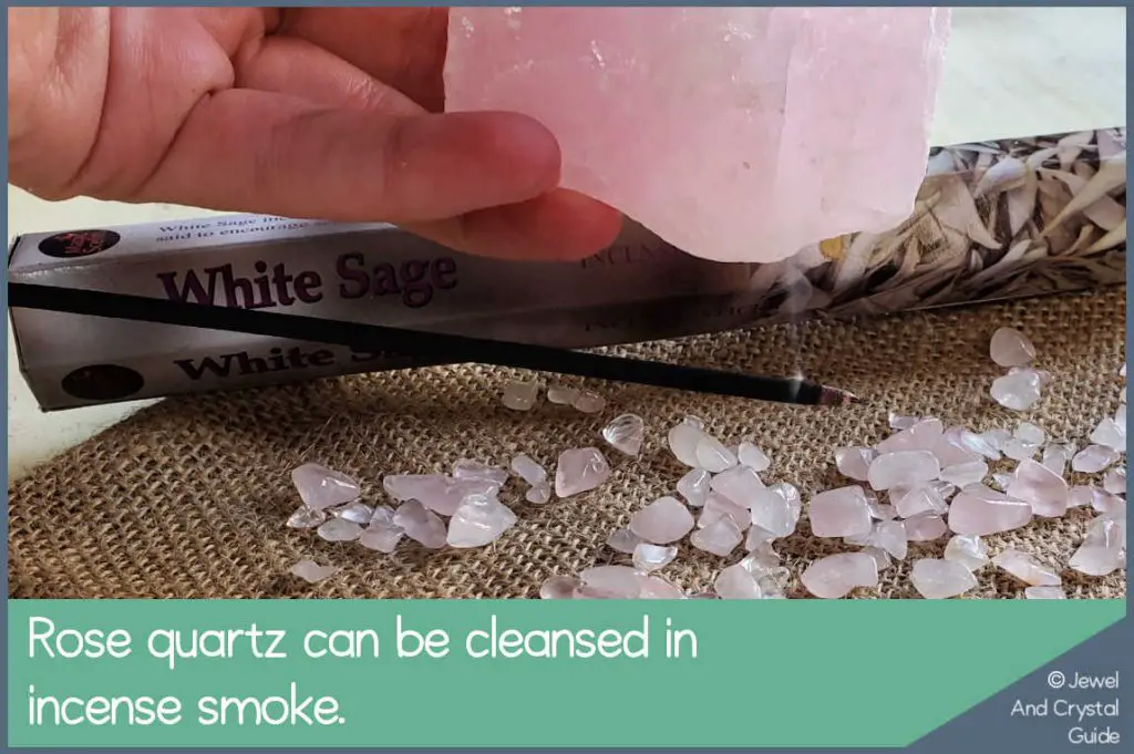 Photo of rose quartz partly covered by incense smoke to be cleansed