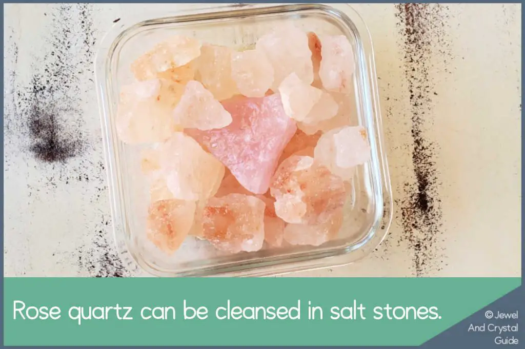 Photo of raw rose quartz and salt stones in a glass bowl for cleansing