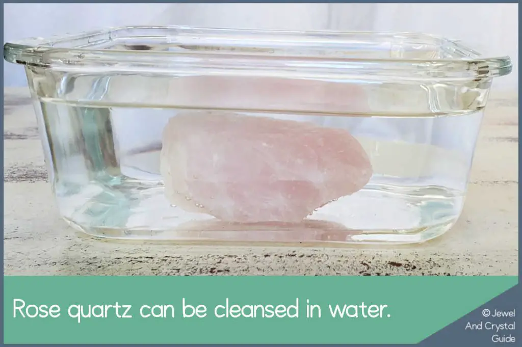 Photo of rose quartz crystal in a bowl of water to be cleansed