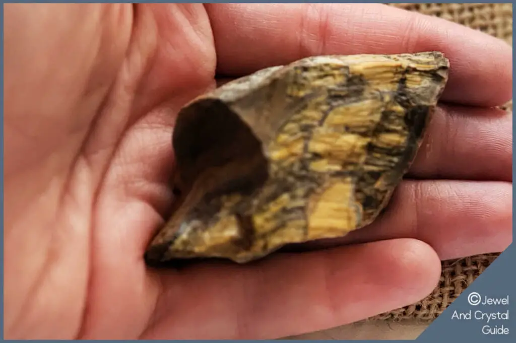 Photo of hand holding tiger's eye to determine if it's real or fake