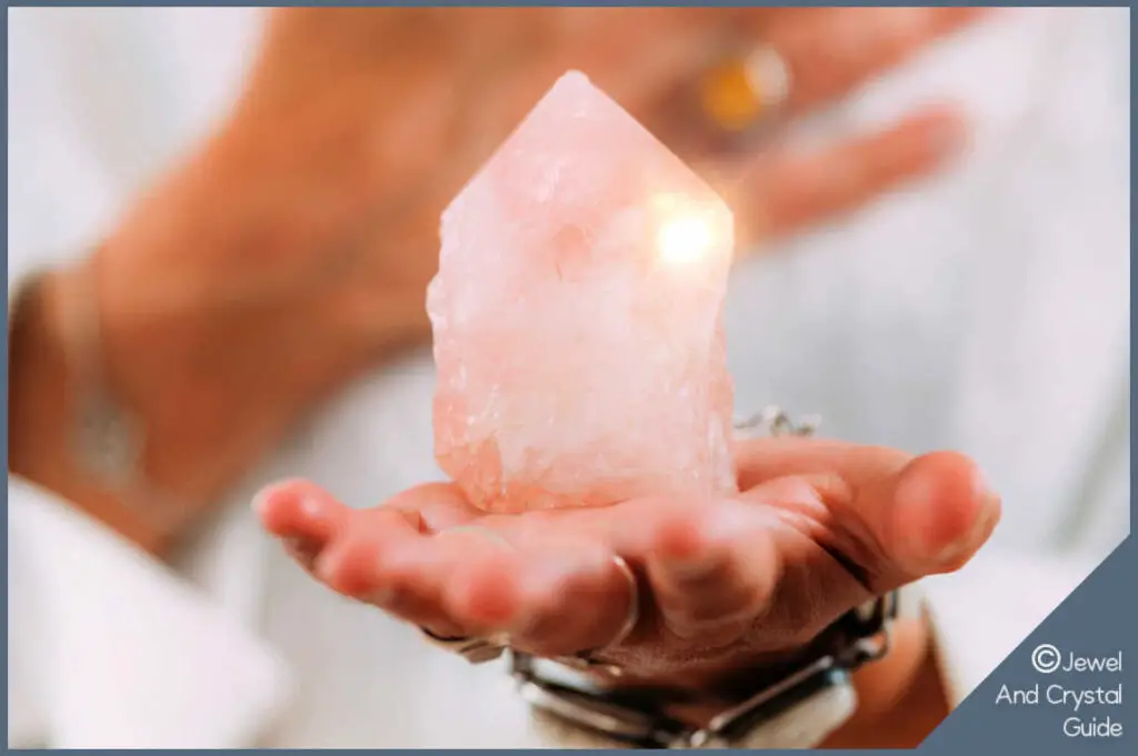 Woman holding rose quartz in one hand and her other hand over her heart