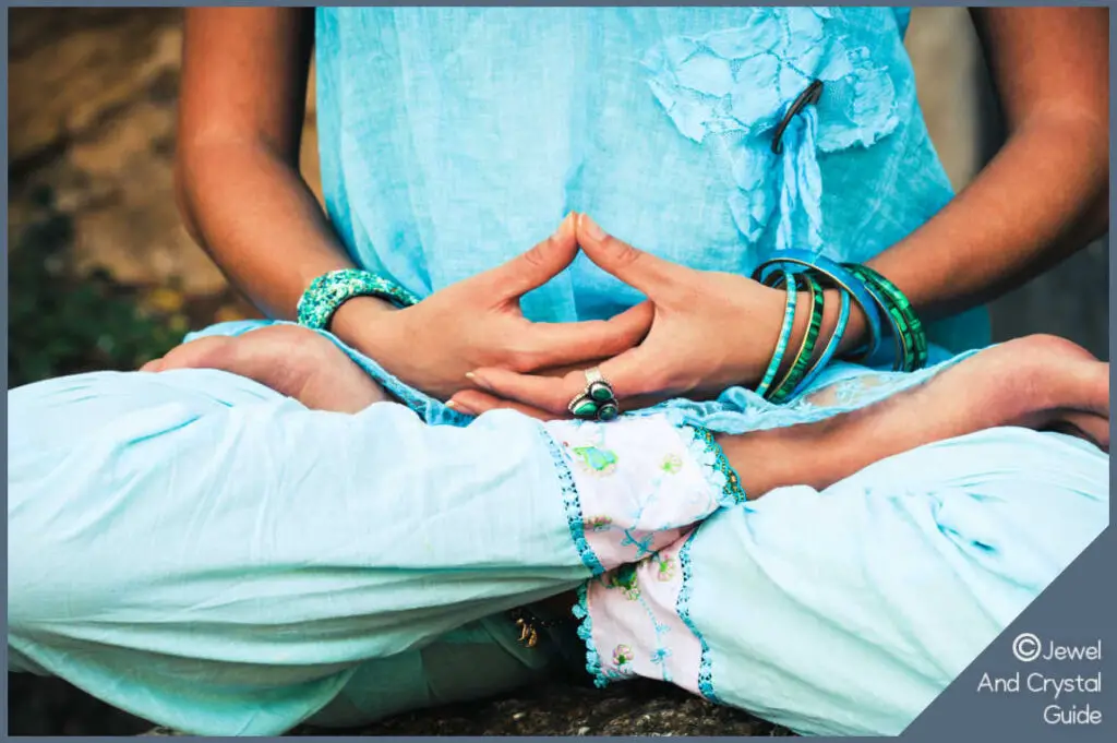 Woman sitting meditating with aventurine jewelry on her wrists